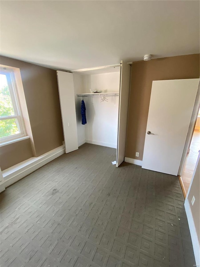 unfurnished bedroom with parquet flooring and a closet