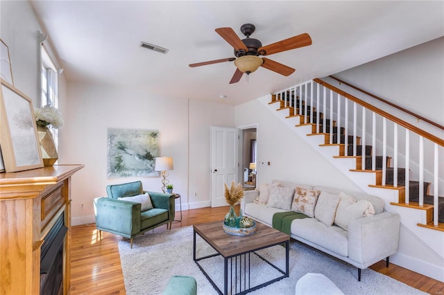 living room featuring light hardwood / wood-style floors and ceiling fan