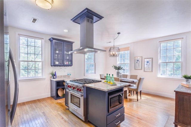 kitchen with island exhaust hood, light hardwood / wood-style flooring, a kitchen island, and stainless steel appliances