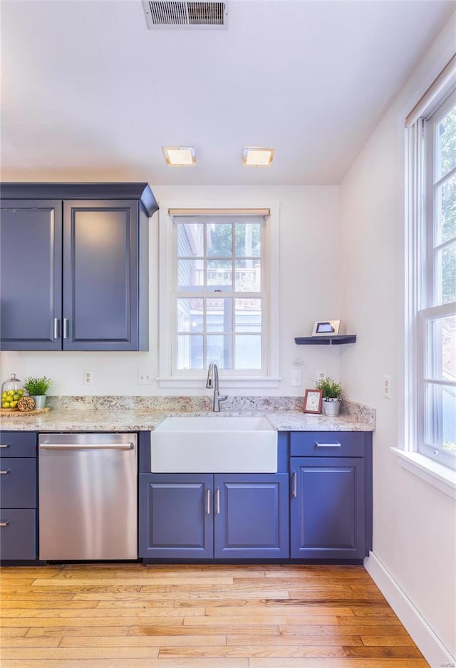 kitchen with light hardwood / wood-style floors, light stone countertops, sink, and stainless steel dishwasher