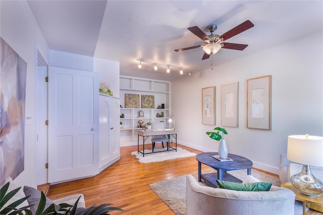 living room with light hardwood / wood-style flooring, ceiling fan, and rail lighting