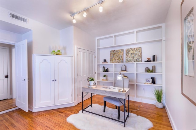 office featuring light wood-type flooring and track lighting