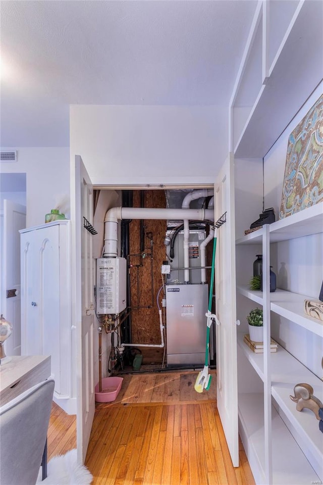 foyer featuring heating unit and hardwood / wood-style flooring