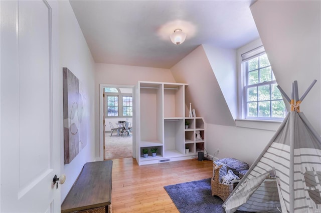 interior space featuring light hardwood / wood-style floors and vaulted ceiling