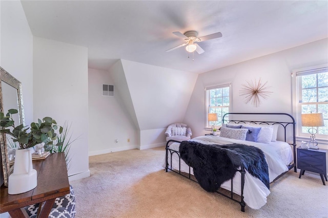 bedroom with vaulted ceiling, light colored carpet, and ceiling fan