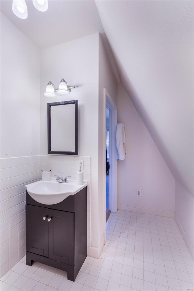 bathroom featuring tile patterned flooring, tile walls, decorative backsplash, lofted ceiling, and vanity