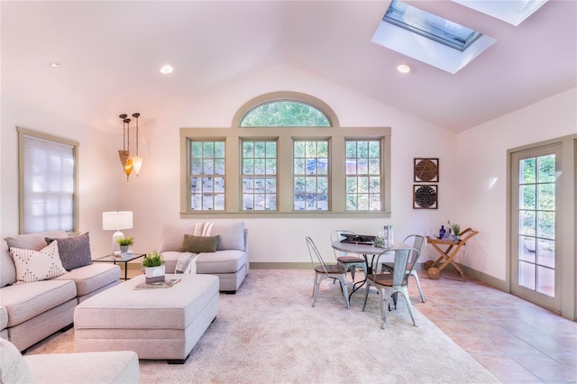 living room featuring a healthy amount of sunlight, light tile patterned floors, and lofted ceiling with skylight