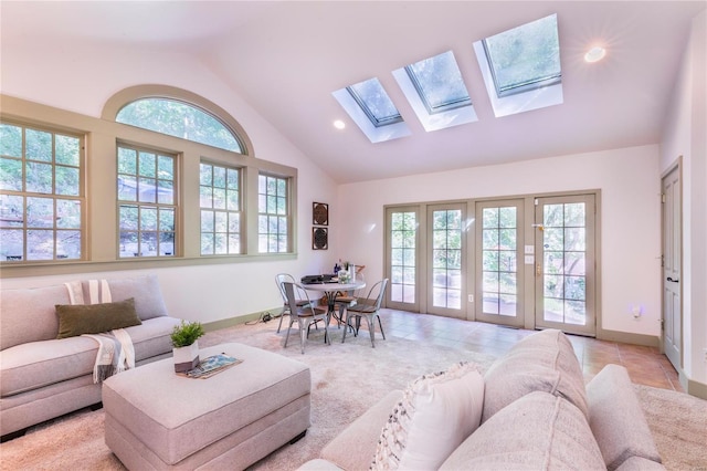 tiled living room featuring a skylight and high vaulted ceiling