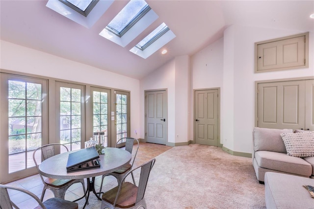 interior space with light tile patterned flooring, high vaulted ceiling, and a skylight