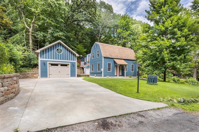 view of front of house featuring a garage, an outbuilding, and a front yard