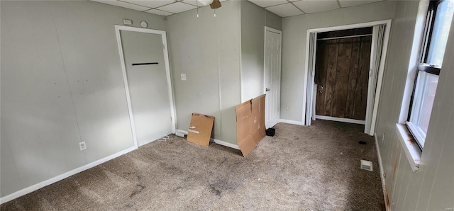 unfurnished bedroom with a drop ceiling and carpet