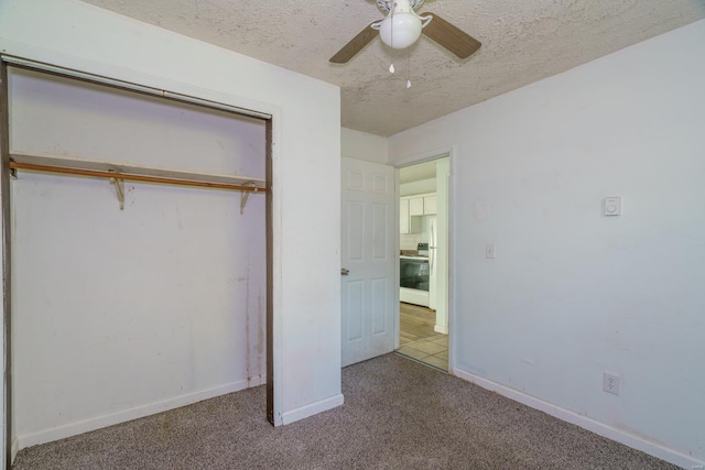 unfurnished bedroom with ceiling fan, light colored carpet, a textured ceiling, and a closet