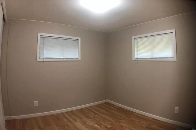 unfurnished room with baseboards and wood finished floors