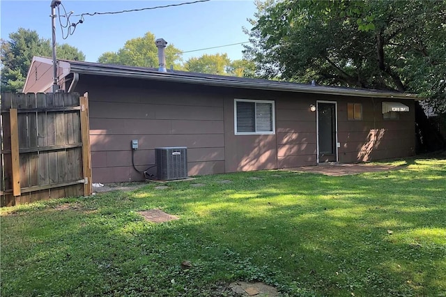 back of house with a yard, central AC unit, and fence