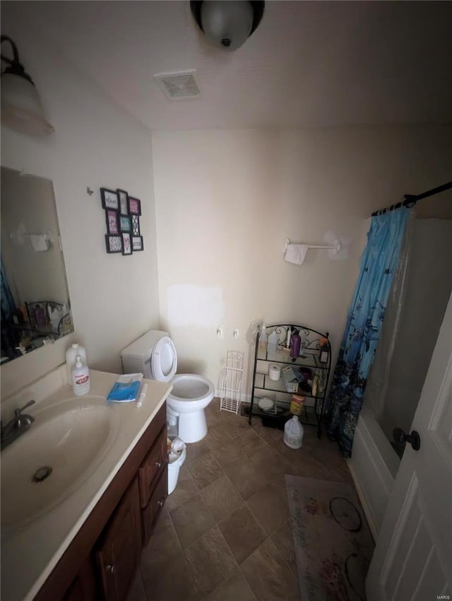 full bathroom with tile patterned flooring, shower / bathtub combination with curtain, toilet, and vanity