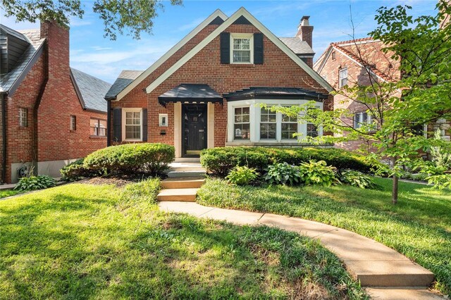 tudor-style house with a front lawn