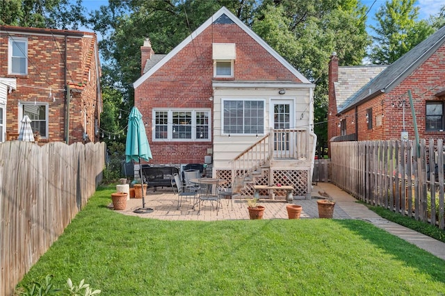 rear view of house featuring a yard and a patio area