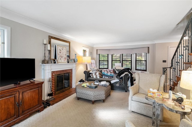 living room with ornamental molding and a brick fireplace