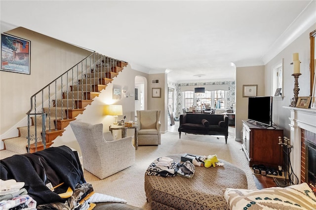 carpeted living room featuring crown molding and a fireplace