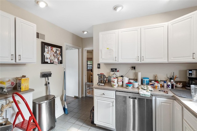 kitchen featuring stainless steel dishwasher, white cabinetry, and light tile patterned floors