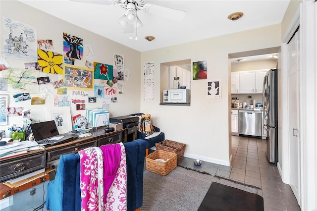 tiled office space featuring ceiling fan