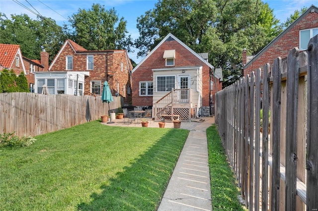 back of property with a patio area and a yard