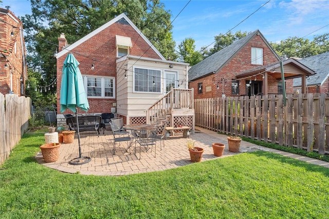 rear view of property featuring a lawn and a patio area