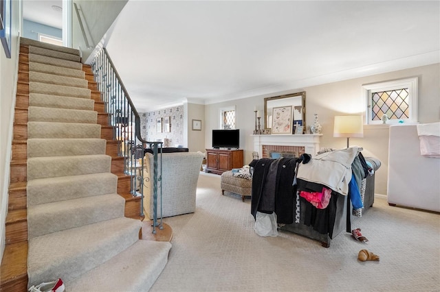 living room featuring a fireplace, plenty of natural light, carpet flooring, and ornamental molding