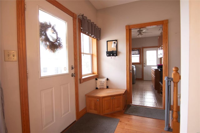 doorway to outside with washer and dryer, light hardwood / wood-style floors, and ceiling fan