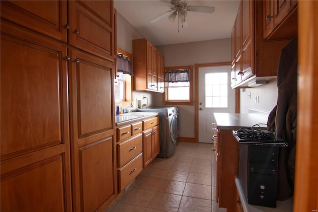 kitchen featuring ceiling fan, light tile patterned floors, and washer and dryer