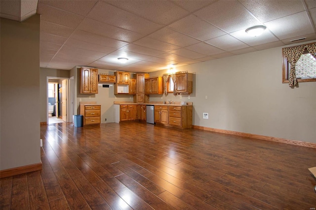 interior space featuring a drop ceiling, sink, and dark wood-type flooring