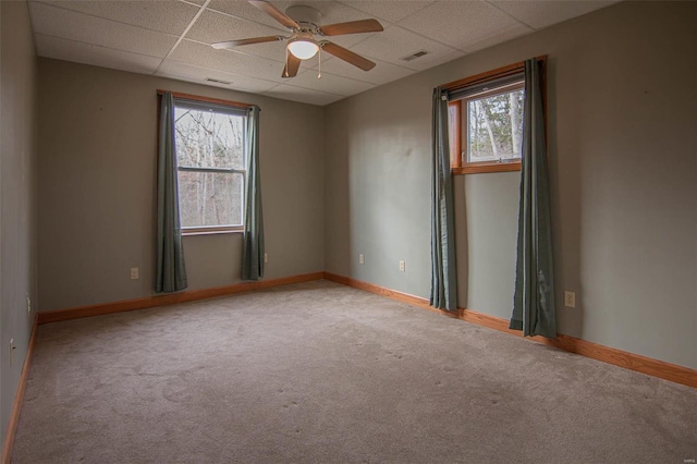 carpeted empty room with a paneled ceiling and ceiling fan