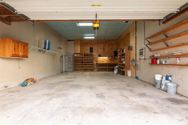 garage with a garage door opener and a wall mounted AC