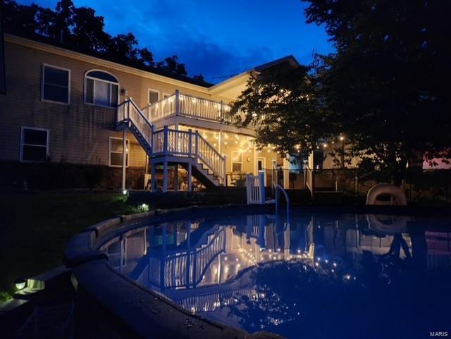 view of pool at twilight