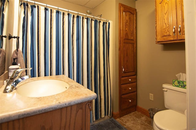 bathroom featuring curtained shower, tile patterned floors, baseboards, vanity, and toilet