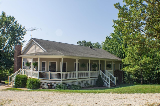 country-style home featuring a porch, a shingled roof, and a chimney