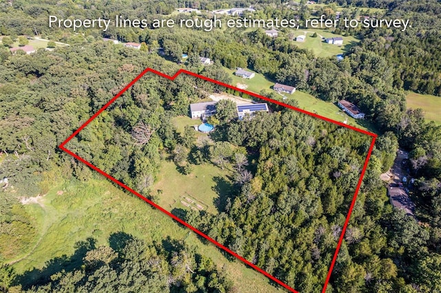 bird's eye view with a wooded view