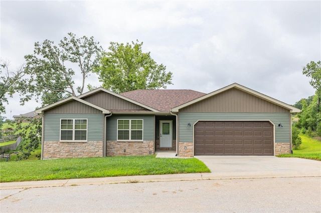 craftsman inspired home with stone siding, concrete driveway, a front lawn, and a garage