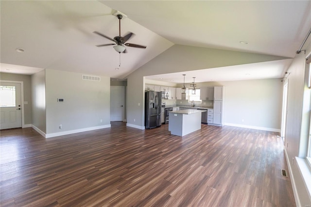 unfurnished living room featuring lofted ceiling, a ceiling fan, visible vents, and dark wood-type flooring