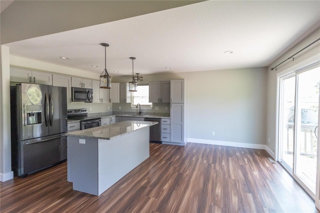 kitchen with appliances with stainless steel finishes, a center island, dark hardwood / wood-style floors, and gray cabinetry