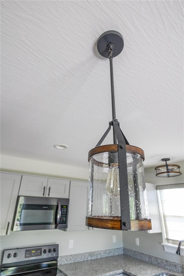 room details featuring gray cabinetry, stainless steel appliances, and light countertops