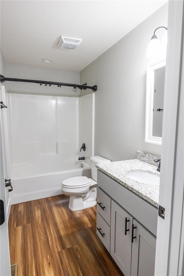 full bathroom with vanity, bathtub / shower combination, hardwood / wood-style flooring, and toilet