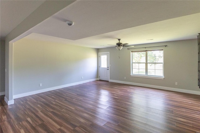 unfurnished room featuring visible vents, baseboards, ceiling fan, and dark wood-style flooring