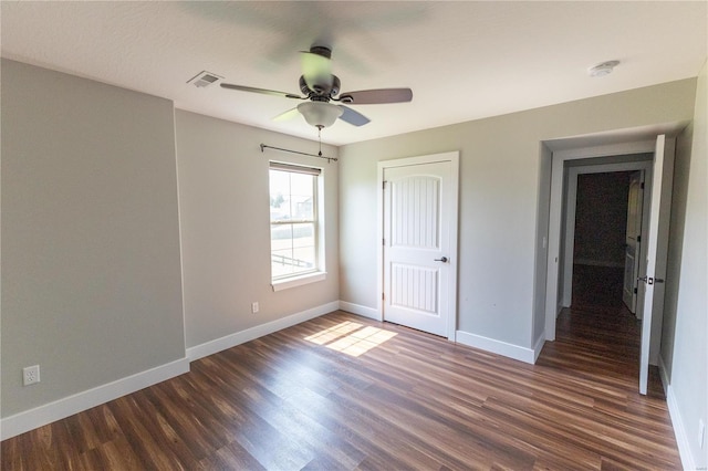 unfurnished bedroom with visible vents, dark wood-type flooring, a closet, baseboards, and ceiling fan