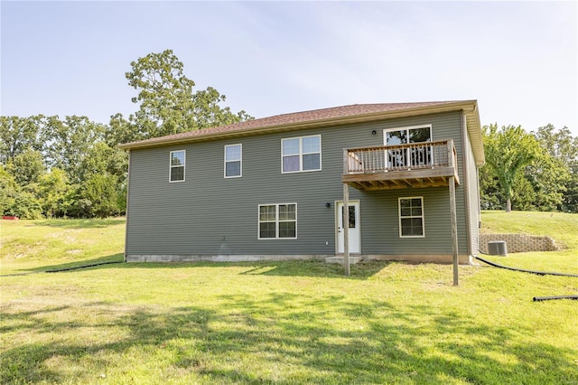 rear view of house featuring a yard, a balcony, and central AC