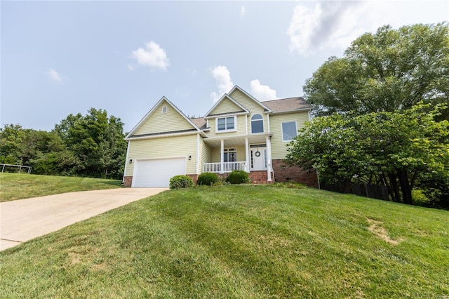 view of front of property featuring a garage, a front yard, and covered porch