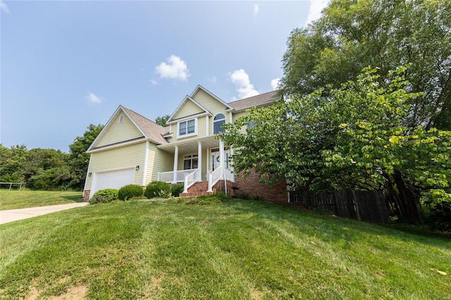 view of front of house with a garage, a front yard, and covered porch