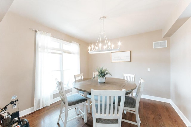 dining space featuring wood-type flooring and a notable chandelier