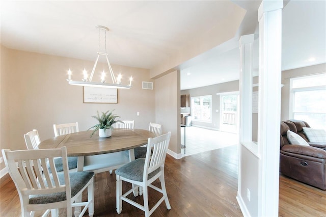 dining room with light hardwood / wood-style flooring, a notable chandelier, and plenty of natural light