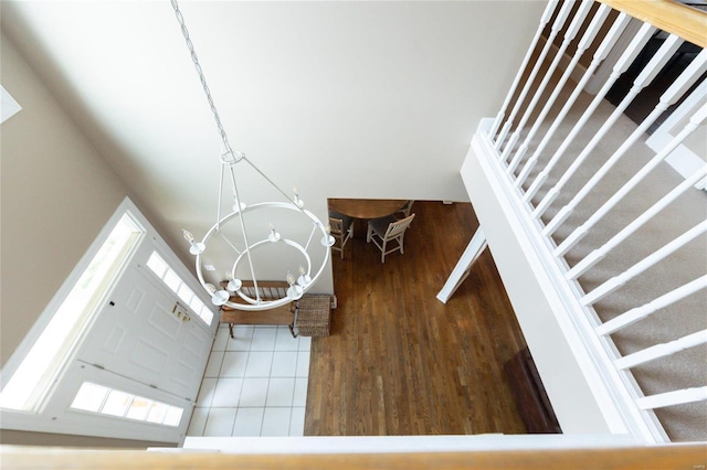 staircase featuring an inviting chandelier and hardwood / wood-style floors